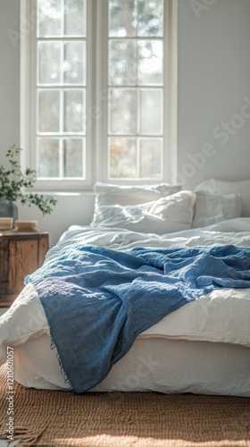 Comfortable bedroom with natural light and green plants enhancing the cozy at...