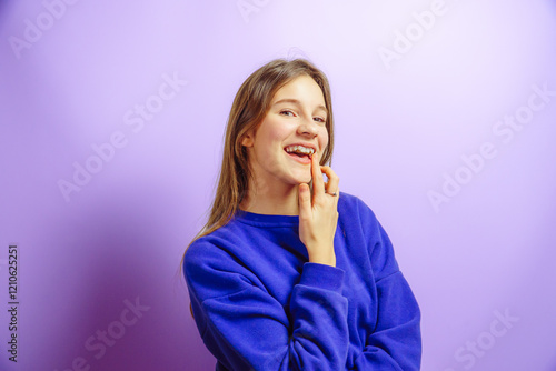 Happy girl with braces smiling on purple studio background