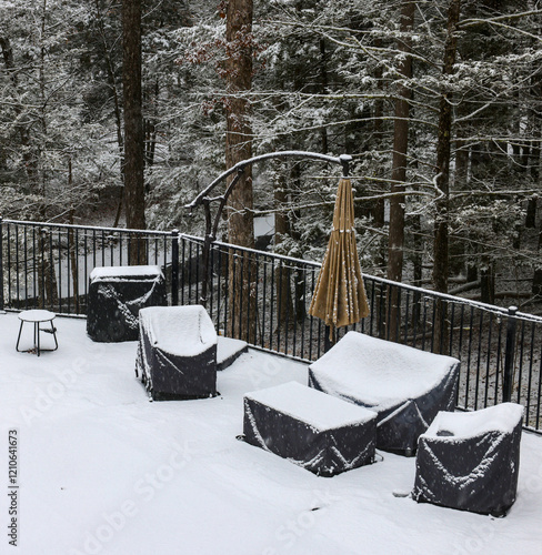 outdoor furniture in back yard covered in snow (poolside patio couch chair coffee table) chairs seating cushion cover protection from elements rain wind snowy weather (folded umbrella) fenced area