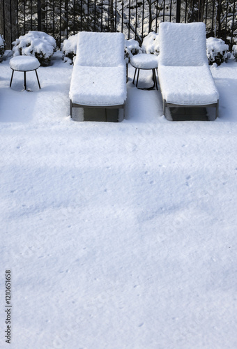 poolside lounge chairs covered in snow during winter (off season spa patio back yard) pool loungers side tables snowy blizzard closed season (recliner reclining chair) end of year photo