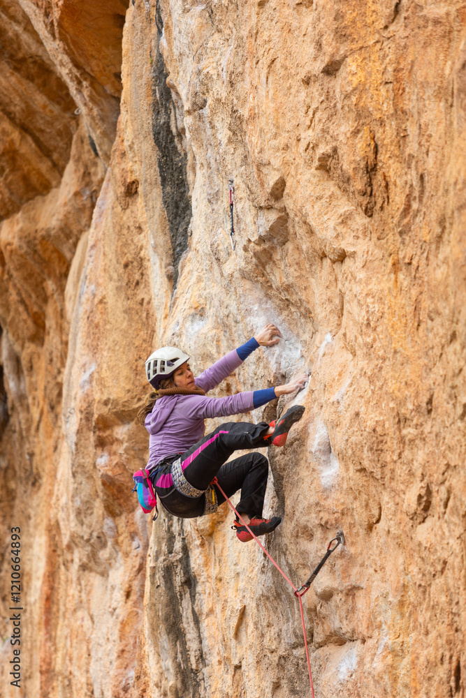 A woman is climbing a rock wall A woman is climbing a rock wall