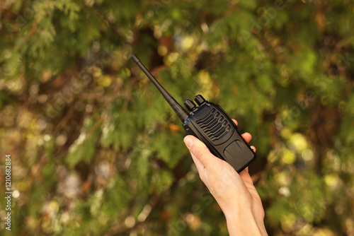 Woman with walkie talkie in park, closeup. Space for text photo