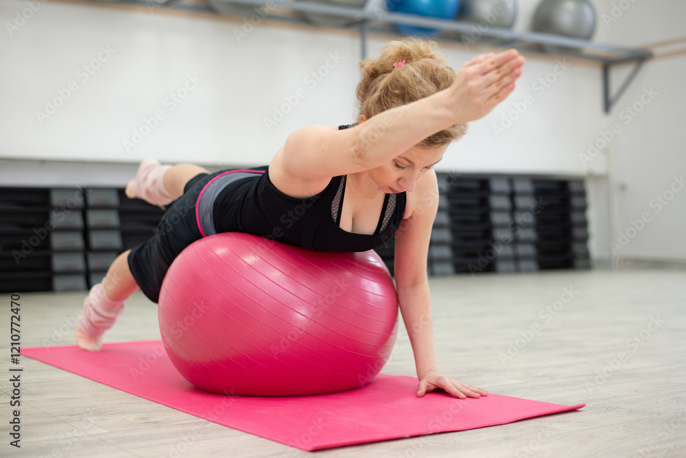Naklejka premium Adult woman practising yoga and pilates in the sports gym