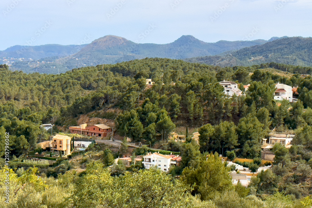 Fototapeta premium Spanish villa in suburb, aerial view. House in rural, view from mountain. Countryside with village houses near farm field. Rural landscape. Villa with garden. House roof in countryside in mountains.