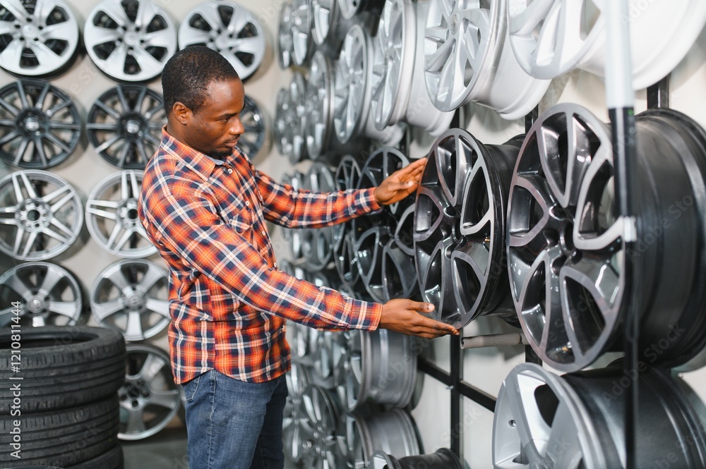African american Car mechanic holding car rims ready to mount the wheels in workshop African american Car mechanic holding car rims ready to mount the wheels in workshop