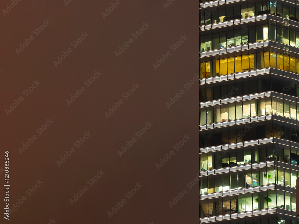 Obraz premium Steel and glass skyscraper buildings illuminated at night, of homes and offices, with copy space