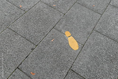 One foot print paint on yellow in pavement,  London,  United Kingdom, 14 November 2024 photo