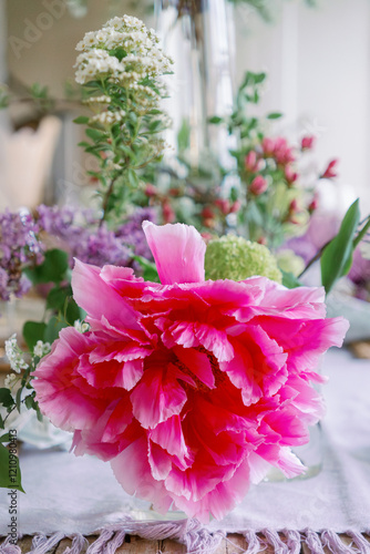 Macro pink tree peony in a bouquet on an elegant farmhouse table