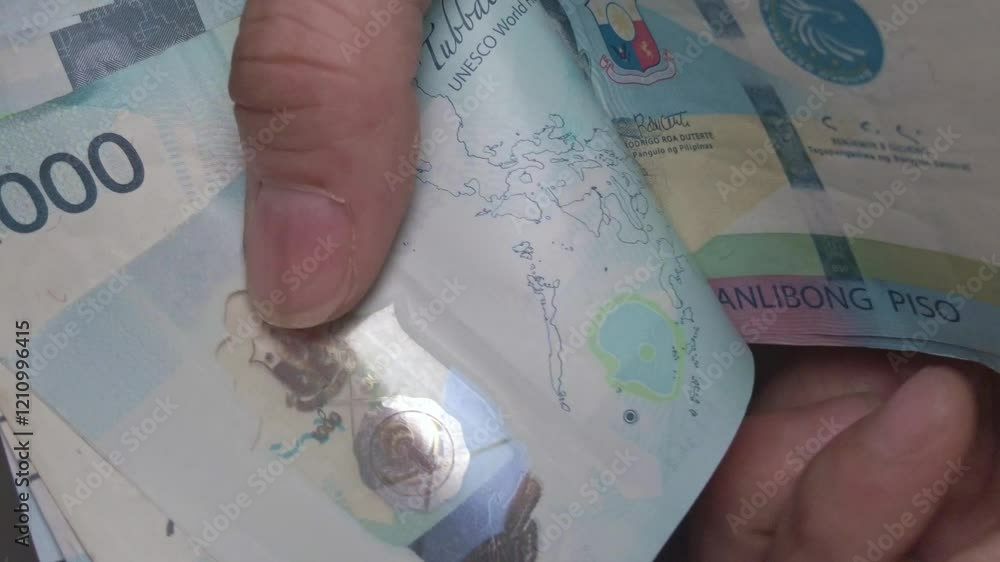 Counting a Pile of cash money 100 Peso Bills