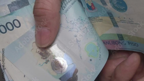 Counting a Pile of cash money 100 Peso Bills