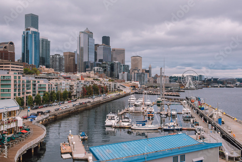 Seattle, USA - Sep 1, 2024 - The Seattle, Washington waterfront and skyline at sunset with a marina and ferris wheel. The Port of Seattle can be seen in the background. photo