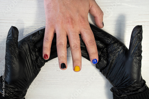 Manicure in progress - Beautiful manicured man's nails with red nail polish. industry of beauty and nail care, beauty salons photo