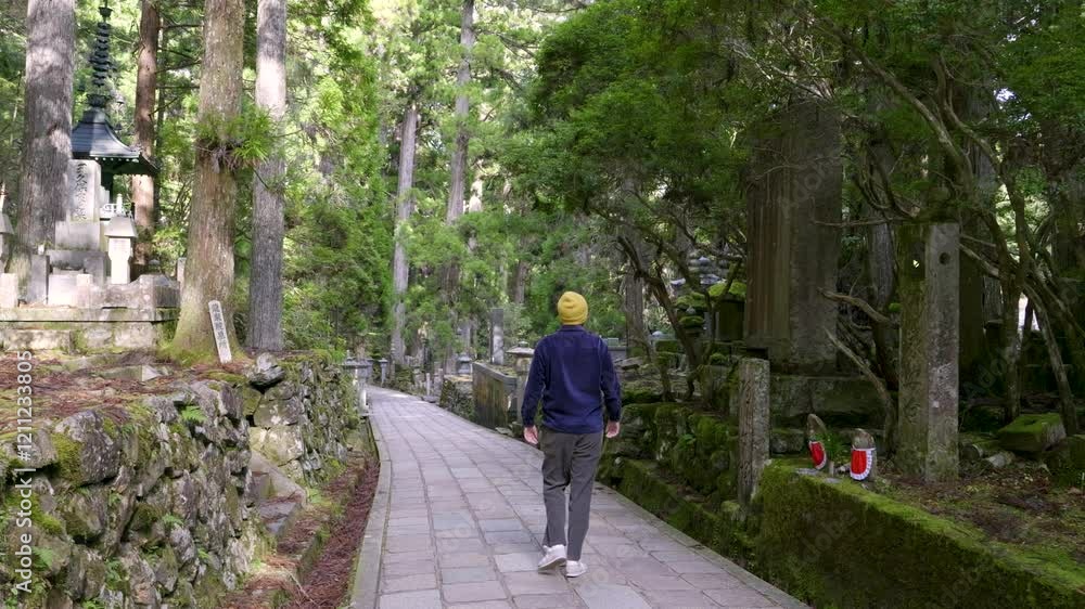 Young male traveler walking through paved road at Koyasan in Japan Young male traveler walking through paved road at Koyasan in Japan