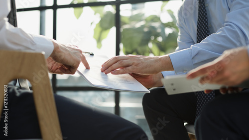 Two business employees reviewing documents in open folder.