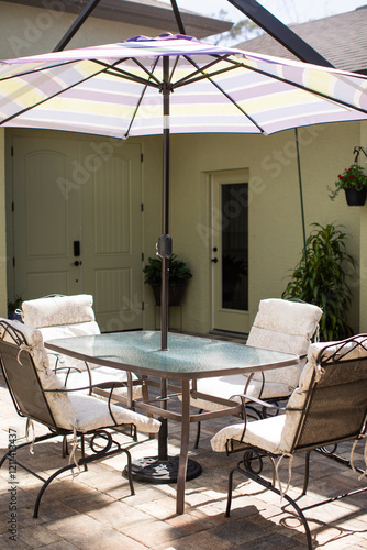 Outdoor glass patio table with cushioned chairs in an enclosed lanai in florida