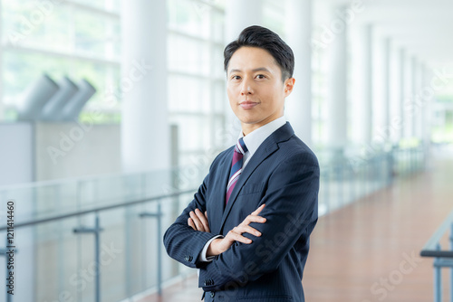 オフィスの廊下に立つビジネスマン