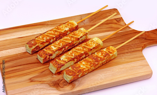 GRILLED COALHO CHEESE FOR BARBECUE ON SKEWER ON WOODEN BOARD ON ISOLATED WHITE BACKGROUND