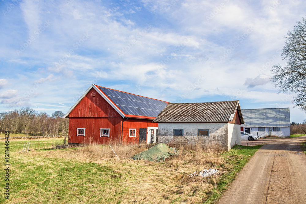 Red barn with solar panels on the roof in the countryside Red barn with solar panels on the roof in the countryside