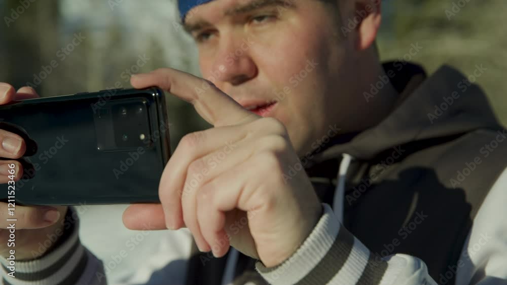 Slow motion close up on man talking photo on his new phone in snowy canyon Slow motion close up on man talking photo on his new phone in snowy canyon