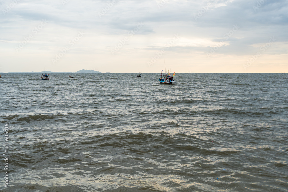 Naklejka premium Fishery boat in sea against sky at Bangsaen, Chonburi. Sunset in bangsan beach