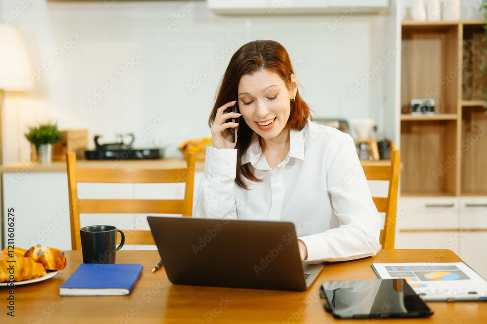 Woman using laptop while sitting at home. Young woman sitting in kitchen and working Woman using laptop while sitting at home. Young woman sitting in kitchen and working