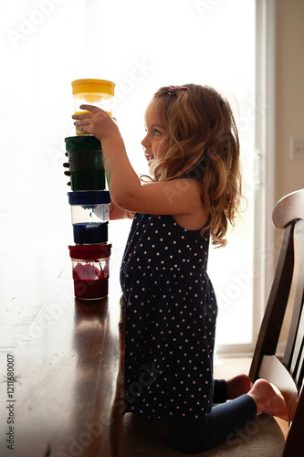 Side view adorable toddler girl stacking paint after art photo