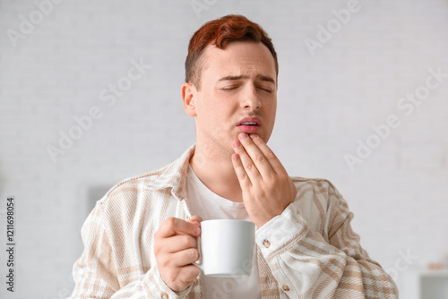 Young man with cup sufferin...