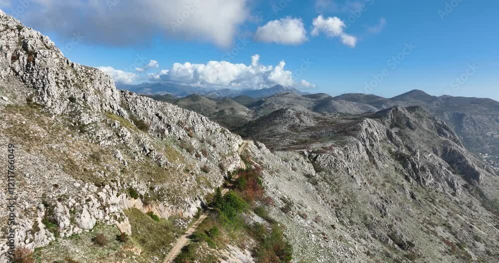 Rocky terrain near Dubrovnik with steep cliffs and grans mountainous views as all terrain offroad vehicle approaches lookout, aerial tracking Rocky terrain near Dubrovnik with steep cliffs and grans mountainous views as all terrain offroad vehicle approaches lookout, aerial tracking