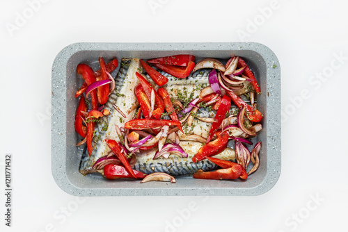 A fish fillet is layered with colorful slices of red peppers and onions, seasoned and arranged neatly in a baking tray, ready for cooking in a warm kitchen photo