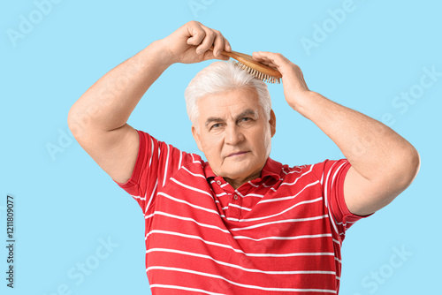 Senior man brushing hair on...