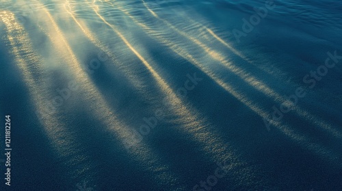 Sunlight rays penetrating the deep blue ocean, casting a soft glow on the rippled sand sea floor photo