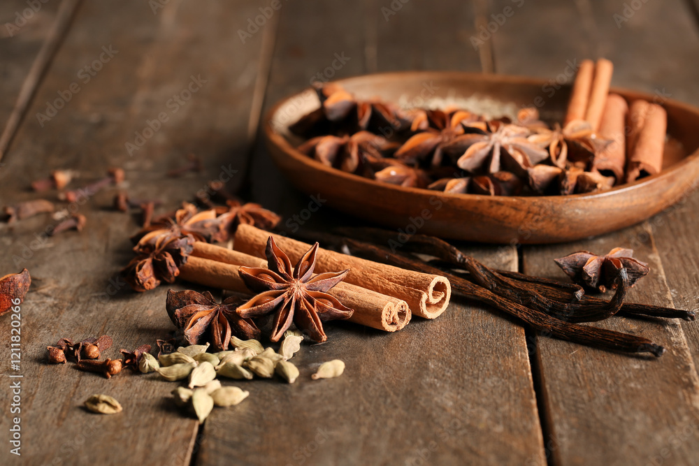 Plate with anise stars, seeds, cinnamon and vanilla sticks on wooden background Plate with anise stars, seeds, cinnamon and vanilla sticks on wooden background