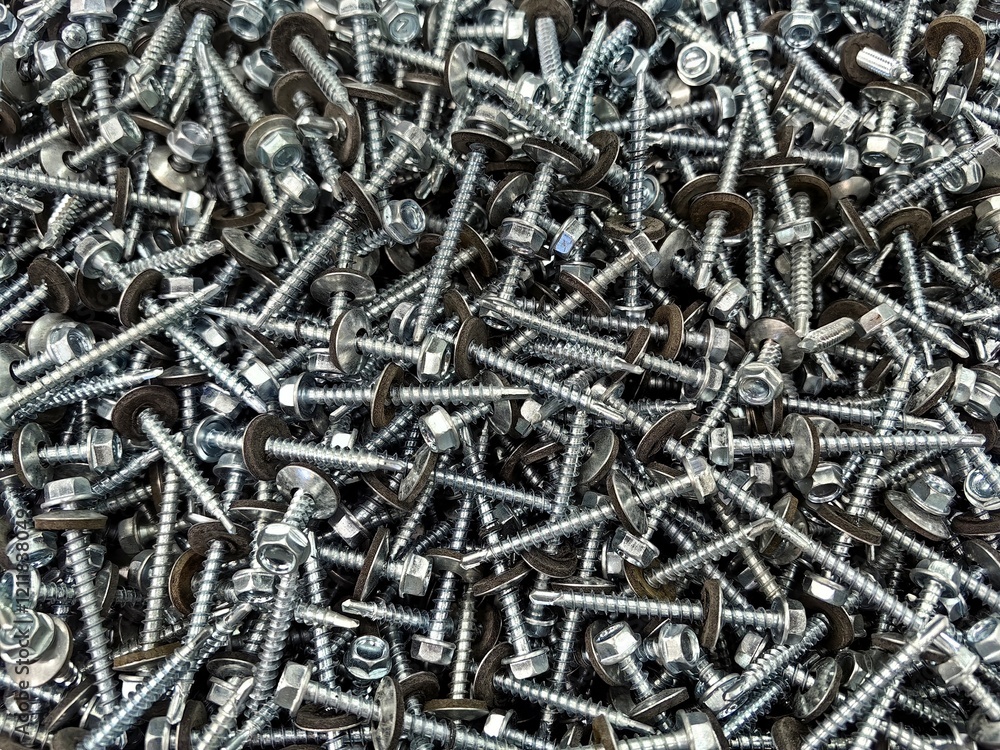 Close-up view of assorted metal screws and bolts scattered on a workbench in a workshop environment Close-up view of assorted metal screws and bolts scattered on a workbench in a workshop environment