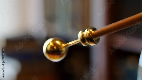 Wallpaper Mural Gold Ball on a Wooden Rod Creating a Stunning Visual Display in a Cozy Indoor Setting Torontodigital.ca