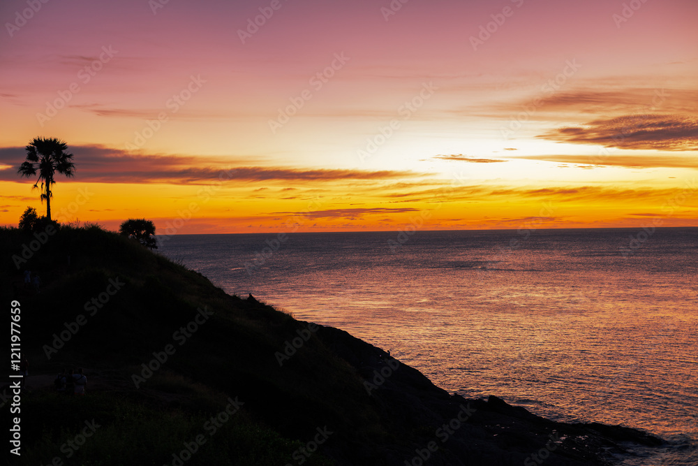 Obraz premium Background of young couples or solo travelers watching the natural light of the sunset at the Phuket seaside, Promthep Cape, a famous viewpoint that travelers from all over the world always visit.