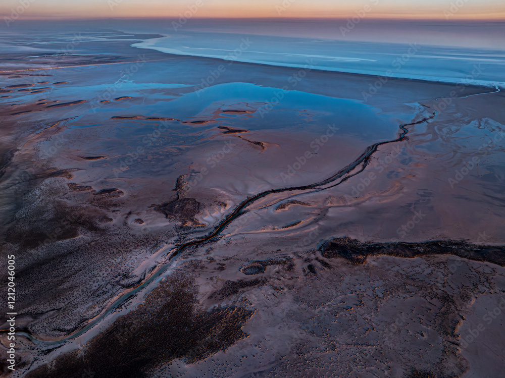Aerial view of river among black sands on the shores of Tuz Lake at sunrise, Turkey