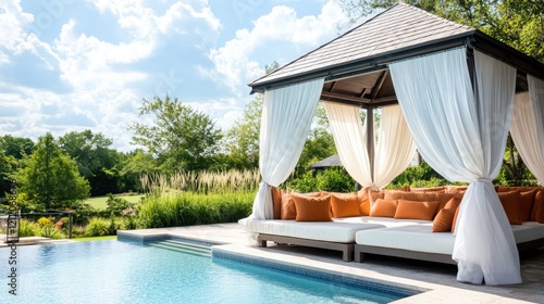 A poolside cabana with soft cushions and curtains fluttering in the breeze.