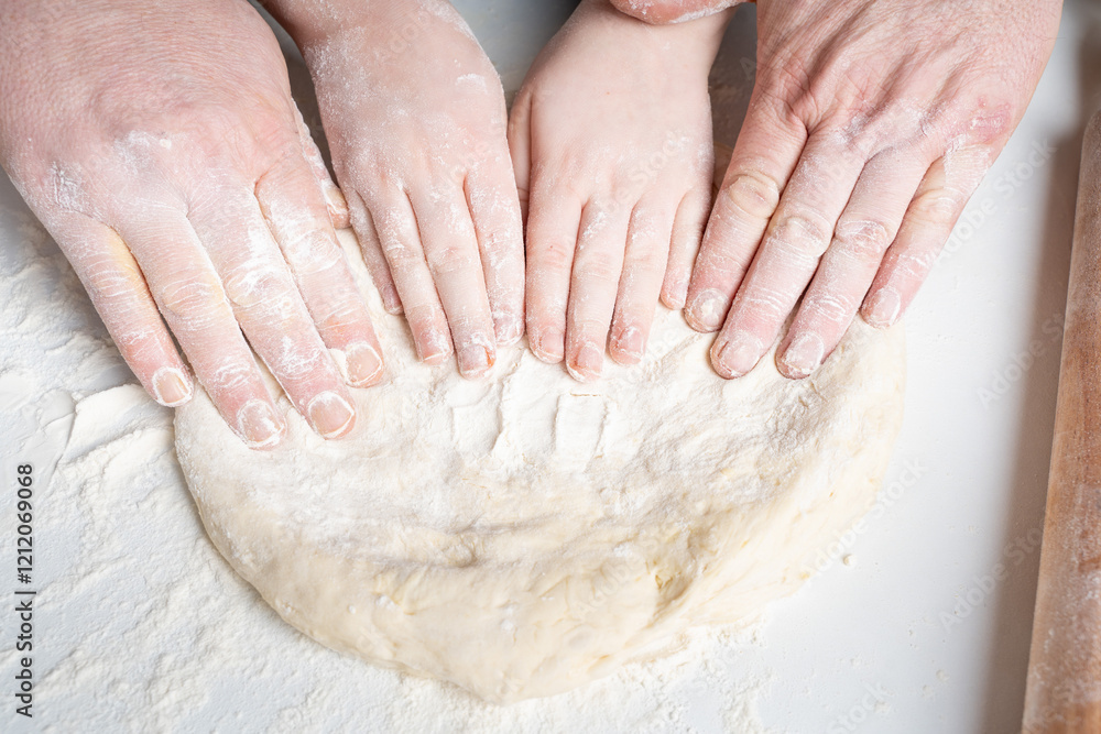 The hands of a man and a child in flour make a pie or pizza from dough. The concept of family relationships, support and love. Spending time together and hobbies. The hands of a man and a child in flour make a pie or pizza from dough. The concept of family relationships, support and love. Spending time together and hobbies.