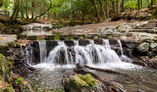 Fast flowing river and rapids in a rocky riverbed in a natural park. Early autumn landscape. photo