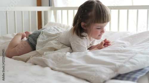 Wallpaper Mural Young child quietly playing alone on a bed in daylight Torontodigital.ca
