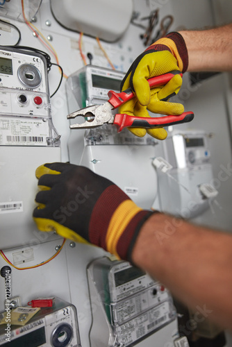 Technician working on a modern electricity power meter station in a building. photo