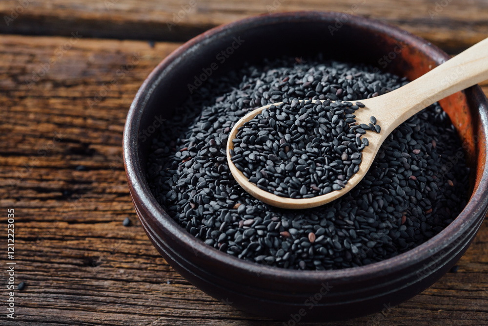 Black sesame in bowl on wooden background