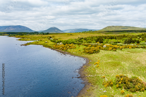 Lough Bofin lake in Connemara region in Ireland. Scenic Irish countryside landscape with magnificent mountains on the horizon, county Galway, Ireland. photo