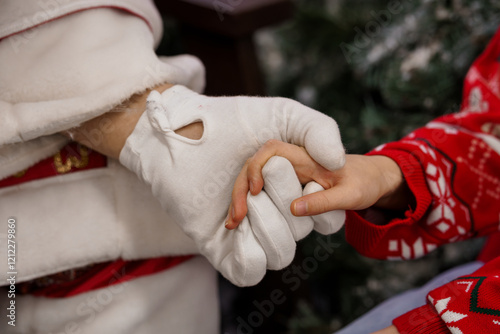 Heartwarming Christmas Moment: Child Holding Santa's Hand