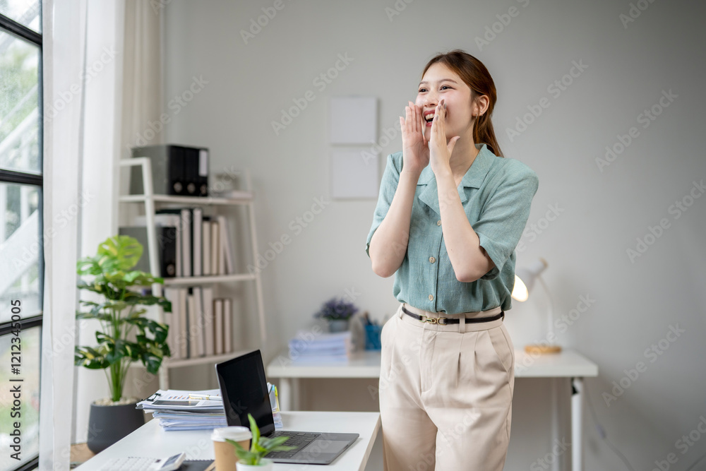 A woman is standing in front of a desk with a laptop and a potted plant A woman is standing in front of a desk with a laptop and a potted plant