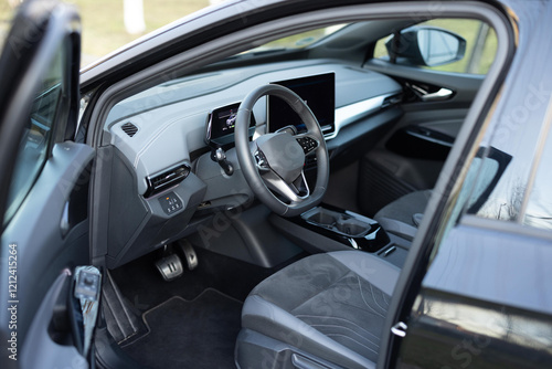 Electric car interior luxury inside. Steering wheel, dashboard, speedometer, display. Gray leather interior. Modern luxury car Interior - steering wheel, shift lever and dashboard
