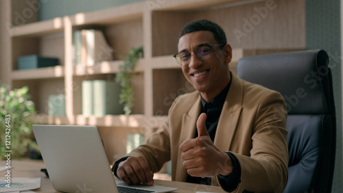 African American 30s millennial business man happy businessman smiling entrepreneur office manager working laptop typing on computer looking camera smile show thumb up gesture aprove recommend like