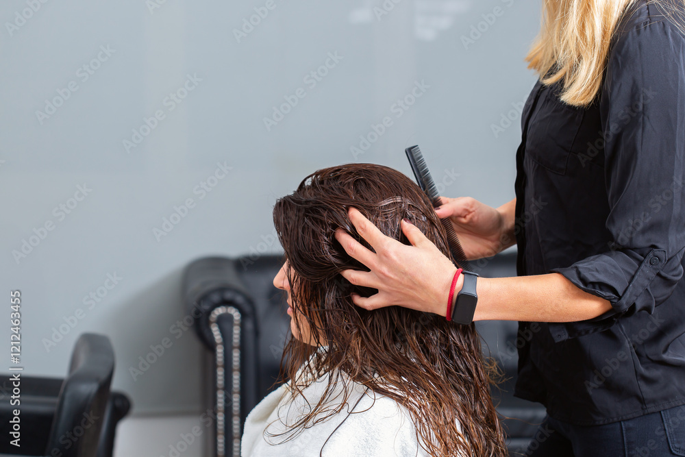 Naklejka premium Hairstylist massages head and scalp for a young female client