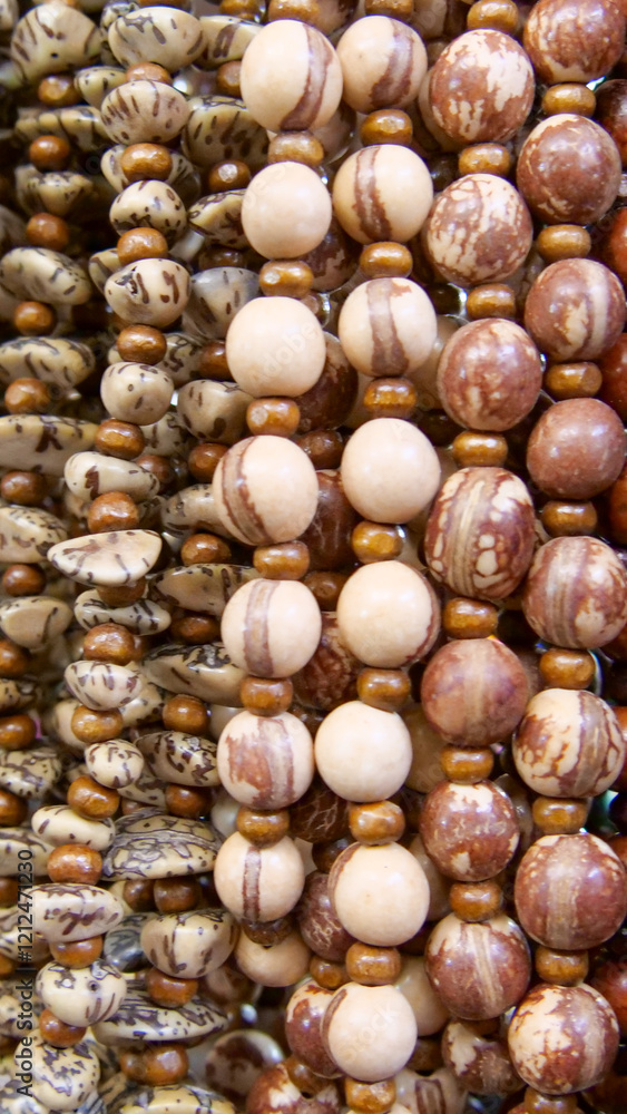 Vertical image of close-up of colorful strings of decorative beads and seeds. Background blurred of out of focus Vertical image of close-up of colorful strings of decorative beads and seeds. Background blurred of out of focus