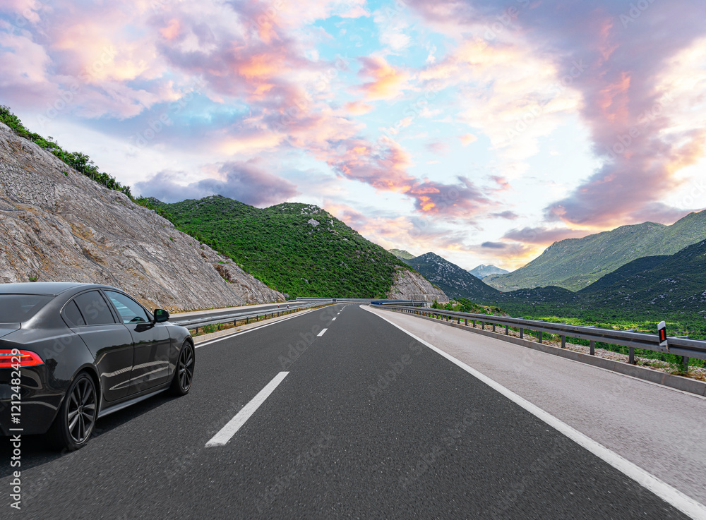 The car is driving along the highway surrounded by picturesque nature.